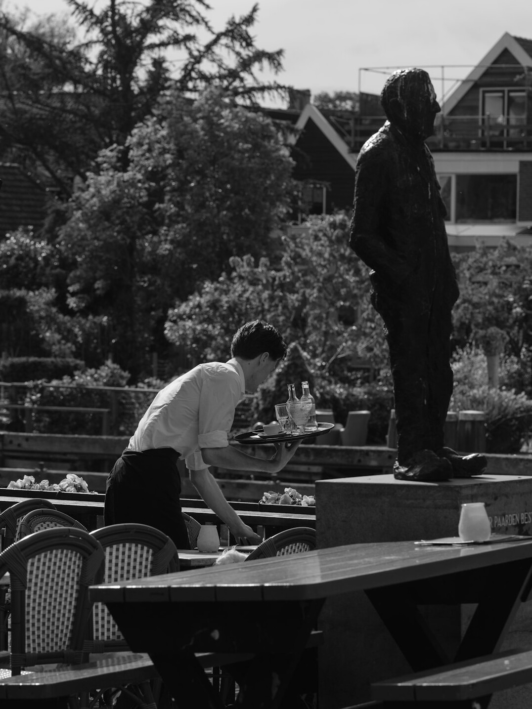 Two people looking together at printed photographs on an outdoor table