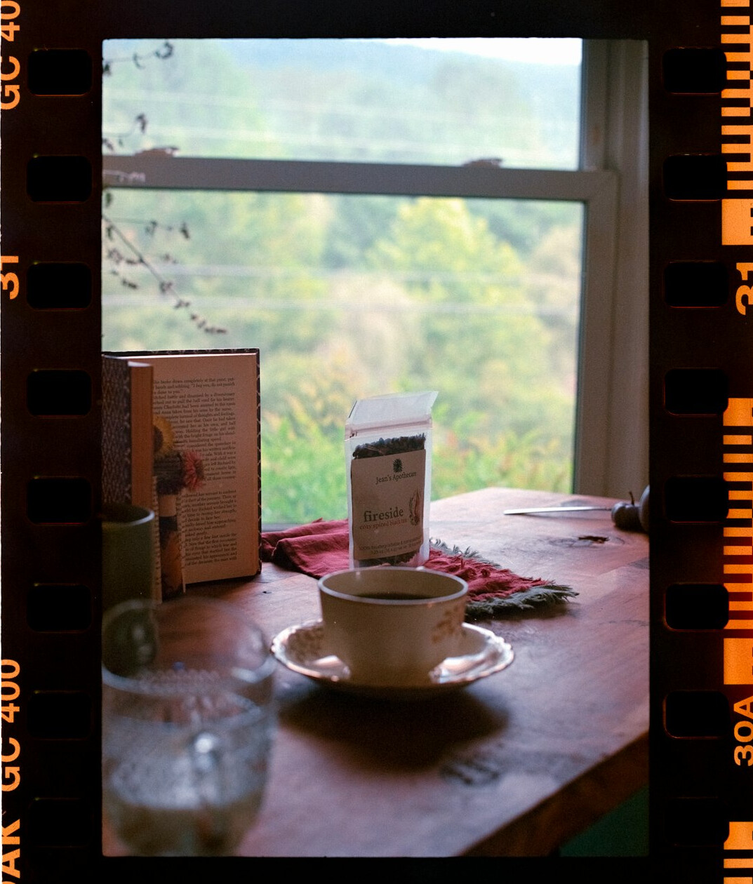 Vintage film camera resting on a wooden table with printed photos